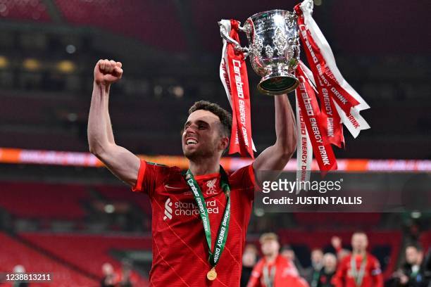 Liverpool's Portuguese striker Diogo Jota holds the winner's trophy after the English League Cup final football match between Chelsea and Liverpool...