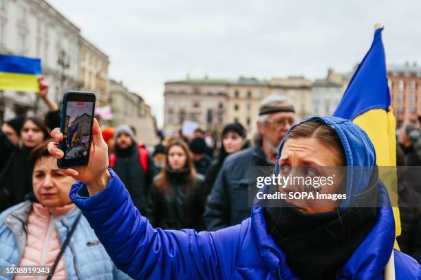 Protester streams live video of demonstration using her smartphone. An anti-war protest by the Ukrainian community, the Poles and Belarusians who...