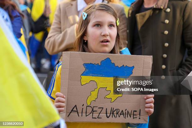 Child holds a placard during the demonstration against Russian military invasion of Ukraine in Marseille.