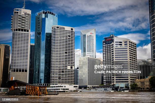 The skyline of the city rises over the swollen Brisbane River in the Queensland city of Brisbane on February 28 following heavy rains and nearby...
