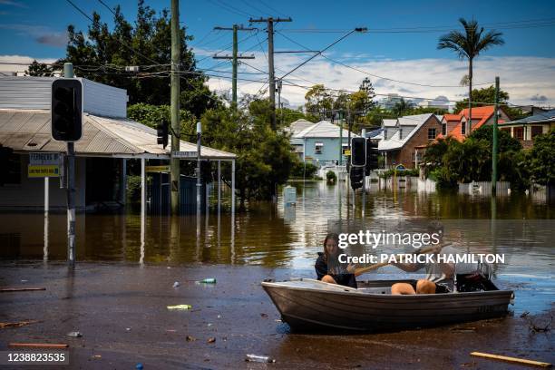 Couple steer their boat through a flooded street in the city of Paddington in suburban Brisbane on February 28, 2022.