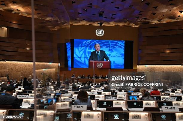 Secretary-General Antonio Guterres appears on a screen as he delivers a remote speech at the opening of a session of the UN Human Rights Council on...