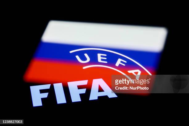 And UEFA logos displayed on phone screens and Russian flag displayed on a phone screen are seen in this multiple exposure illustration photo taken in...