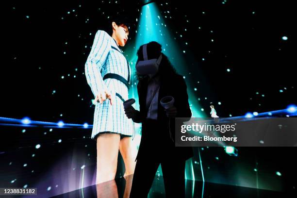 An attendee wearing a virtual reality headset takes part in a concert experience in the metaverse at the SK Telecom Co. Stand on the opening day of...