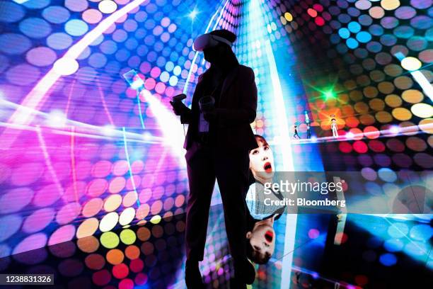 An attendee wearing a virtual reality headset takes part in a concert experience in the metaverse at the SK Telecom Co. Stand on the opening day of...