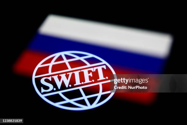 Logo displayed on a phone screen and Russian flag displayed on a phone screen are seen in this multiple exposure illustration photo taken in Krakow,...