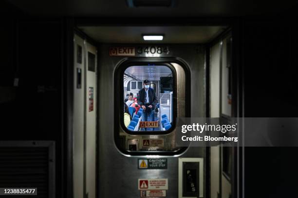 Passenger walks through a train car on an Amtrak train near Memphis, Tennessee, U.S., on Friday, Feb. 25, 2022. Amtrak is expecting to receive $22...