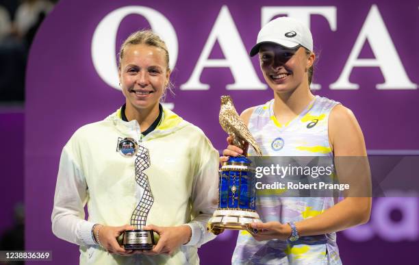 Runner-up Anett Kontaveit of Estonia and champion Iga Swiatek of Poland pose with their trophies after the final of the Qatar TotalEnergies Open at...