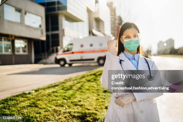 brave optimistic paramedic in the front lines,working in a isolation hospital facility with infected patients.covid-19 emergency room triage doctor with protective glasses / mask.fighting coronavirus - triage tent stock pictures, royalty-free photos & images