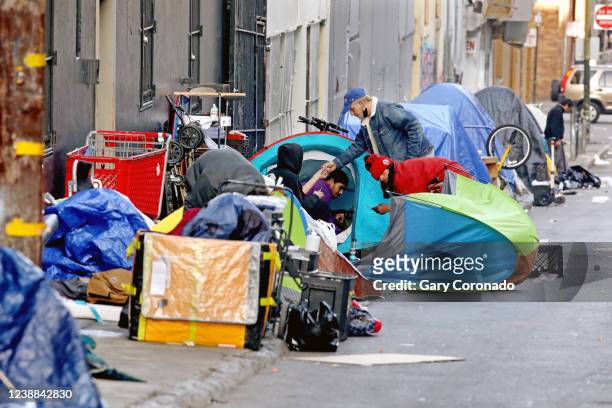 Homeless people consume illegal drugs in an encampment along Willow St. In the Tenderloin district of downtown on Thursday, Feb. 24, 2022 in San...