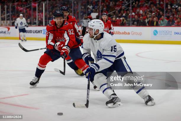 Alexander Kerfoot of the Toronto Maple Leafs controls the puck as he is pressured by Evgeny Kuznetsov of the Washington Capitals during a game at...