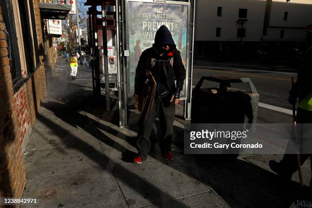 Man has to move his belongings as San Francisco Public Works pressure washes the sidewalk along Eddy St. In the Tenderloin district of downtown on...