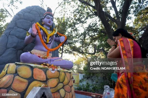 Hindu devotee offers prayers to a statue of the Hindu god Lord Shiva on the occasion of Maha Shivaratri festival, outside a Shiva Temple temple in...