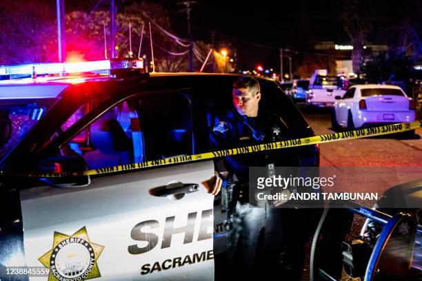 Sacramento County Sheriff's Department officer looks on near the crime scene outside a church where a man shot dead four people, including three of...