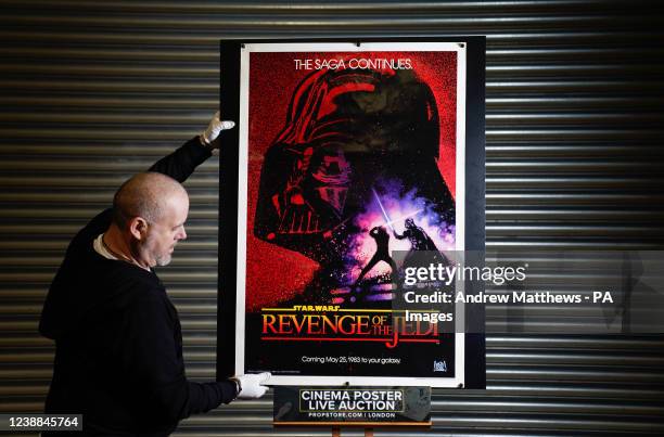 Prop Store poster consultant Mark Hochman adjusts a US one-sheet for Star Wars: Revenge of the Jedi during a preview at their auction house in...