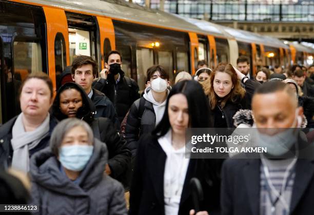 Commuters, some wearing face coverings due to Covid-19, exit a Transport for London London Overground train service from Walthamstow, after arriving...
