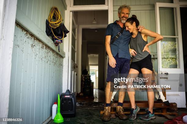 Paul Skinner and Jill Schmidt embrace each other in the flood-damaged suburb of Newmarket in Brisbane on March 1, 2022.