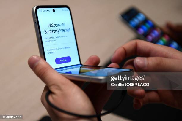 Person checks South Korean tech giant Samsung's Galaxy Z Flip 3 smartphone, in the MWC in Barcelona on March 1, 2022. - One of the technology...