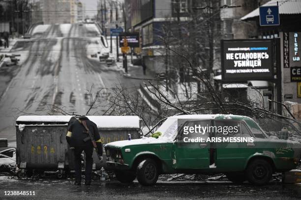 An armed man stands at a road block in downtown Kyiv on March 1, 2022. - Ukrainian President described Russian shelling of his country's second city...