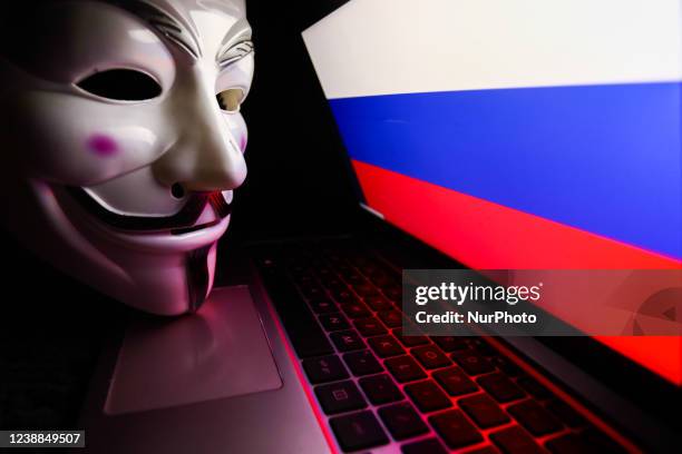 Russian flag displayed on a laptop screen and Guy Fawkes mask are seen in this illustration photo taken in Krakow, Poland on March 1, 2022. Global...