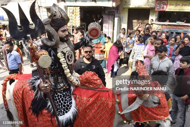 An artist dressed as Hindu god Lord Shiva sit on a cow as he takes part in a religious procession on the occasion of 'Maha Shivaratri' festival, in...