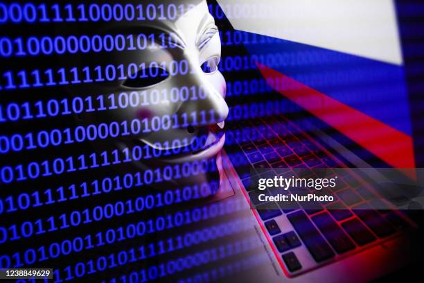 Russian flag displayed on a laptop screen, Guy Fawkes mask and binary code displayed on a screen are seen in this multiple exposure illustration...