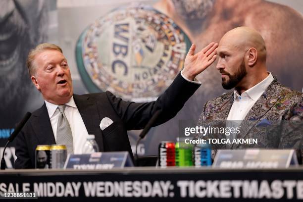 Promoter Frank Warren gestures towards World Boxing Council heavyweight title holder Britain's Tyson Fury reacts during a press conference at Wembley...