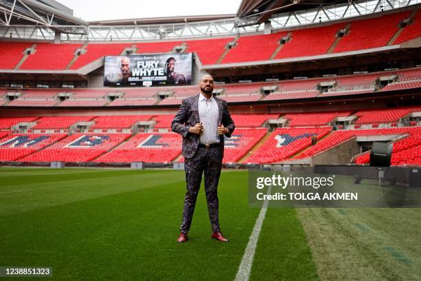 World Boxing Council heavyweight title holder Britain's Tyson Fury poses on the pitch after a press conference at Wembley Stadium in west London on...