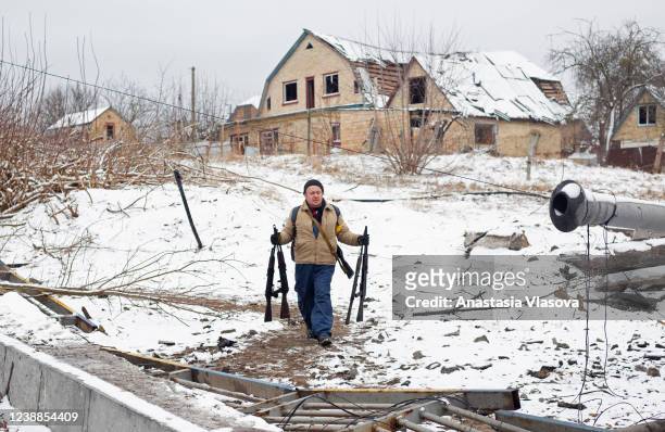 Man carries assault rifles on March 1, 2022 in Irpin, Ukraine. Russian forces continued to advance on the Ukrainian capital of Kyiv as their invasion...