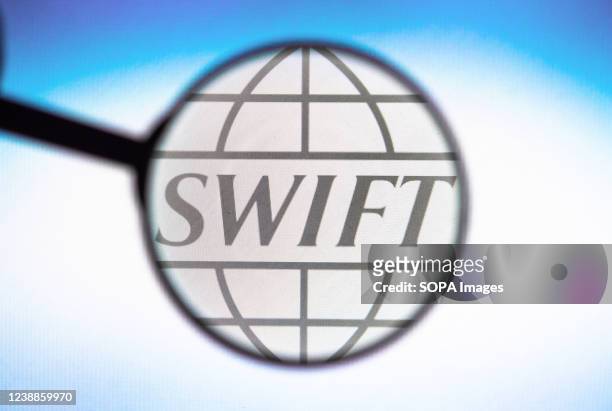 In this photo illustration, a Society for Worldwide Interbank Financial Telecommunication logo seen displayed on a computer screen through a...