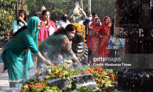 Hindu Devotees offer milk and water over a Shivling inside a temple during the Maha Shivratri festival at Shiv temple Preet Vihar on March 1, 2022 in...