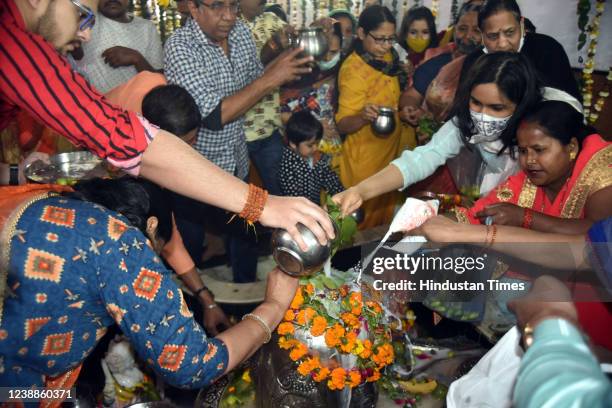 Hindu Devotees offer milk and water over a Shivling inside a temple during the Maha Shivratri festival at Shiv temple Preet Vihar on March 1, 2022 in...