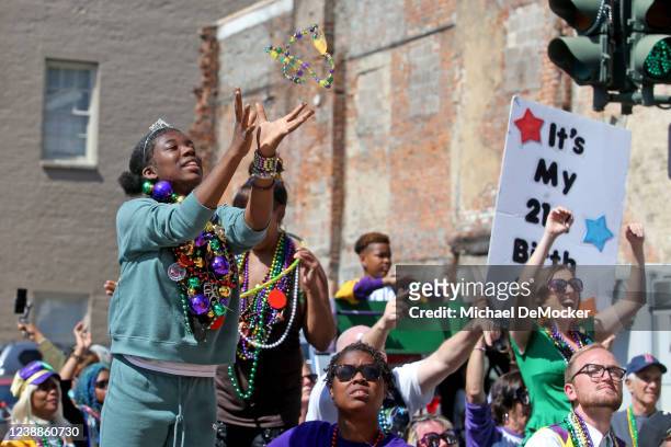 Parade-goer catches a string of beads as the 1,500 members of the Krewe of Zulu make their way down St. Charles Avenue on Mardi Gras Day with their...