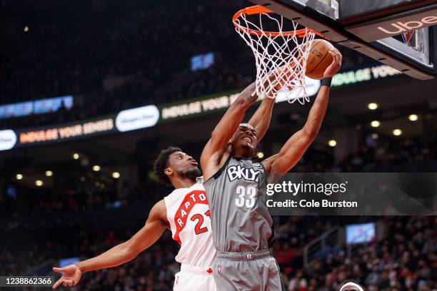 Nic Claxton of the Brooklyn Nets tries to get a shot up over Thaddeus Young of the Toronto Raptors during the first half of their NBA game at...