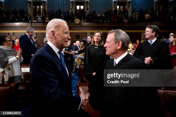 President Joe Biden shakes hands with Supreme Court Chief Justice John Roberts while arriving to deliver the State of the Union address during a...