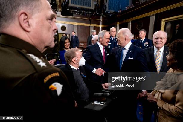 President Joe Biden speaks to Sen. Tom Carper after delivering the State of the Union address to a joint session of Congress in the U.S. Capitol...