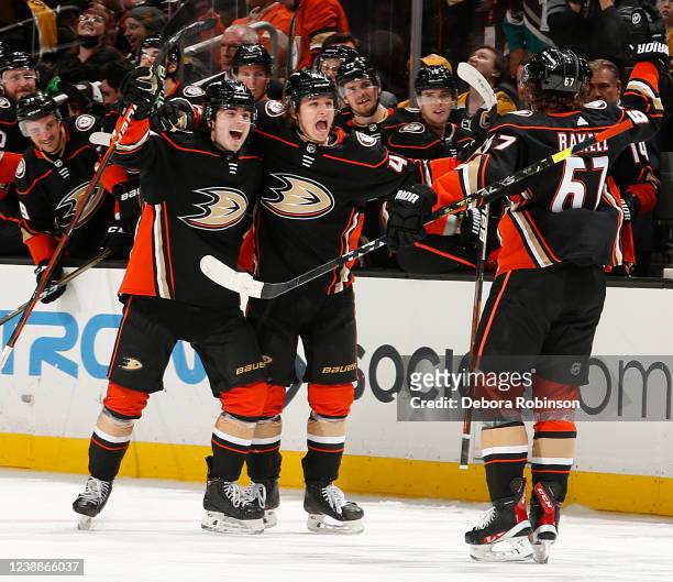 Jamie Drysdale, Trevor Zegras, and Rickard Rakell of the Anaheim Ducks celebrate a game-winning goal in the third period against the Boston Bruins at...