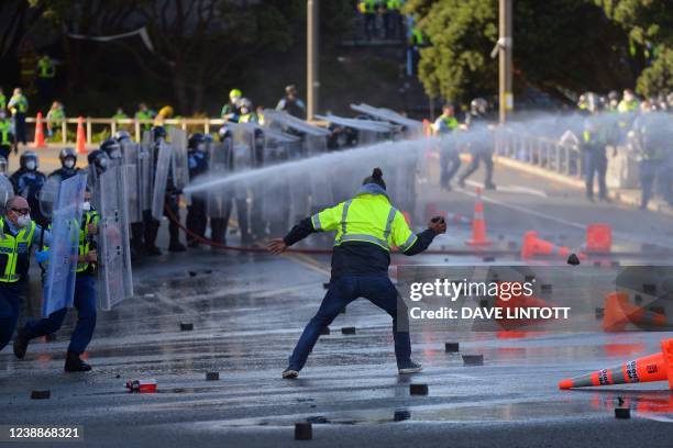 Man faces off with police near the parliament as police move in to clear protesters in Wellington on March 2 during demonstrations against Covid-19...