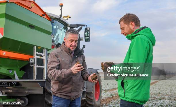 March 2022, Saxony, Grimma: Farmer and company boss Bernd Schicketanz explains to Michael Kretschmer , Minister President of Saxony, the use of...