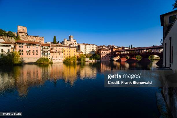 The bridge Ponte Vecchio, Ponte degli Alpini, leading over the river Brenta in Bassano del Grappa, facades of medieval houses reflecting in the water.
