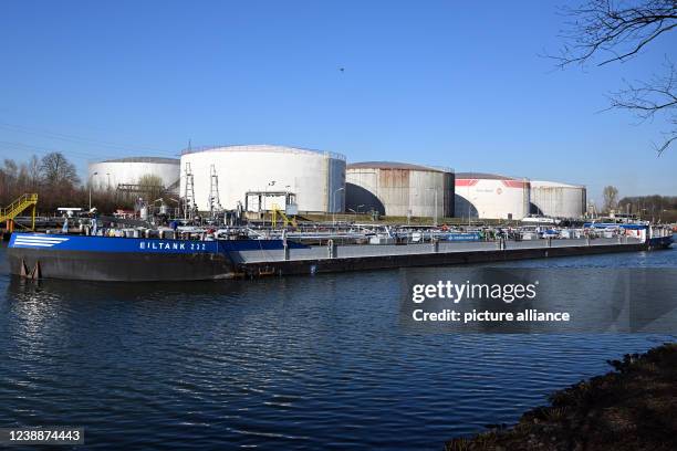 March 2022, North Rhine-Westphalia, Gelsenkirchen: A tanker passes oil tanks on the Rhine-Herne Canal. High prices for energy and electricity are...