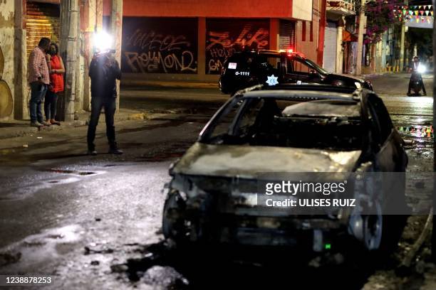 Mexican journalist Martin Patino talks to a witness at the scene of a vehicle fire while on security duty for a local television station in...