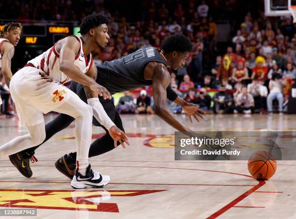 Tyrese Hunter of the Iowa State Cyclones and Bryce Williams of the Oklahoma State Cowboys chase a loose ball in the second half at Hilton Coliseum on...