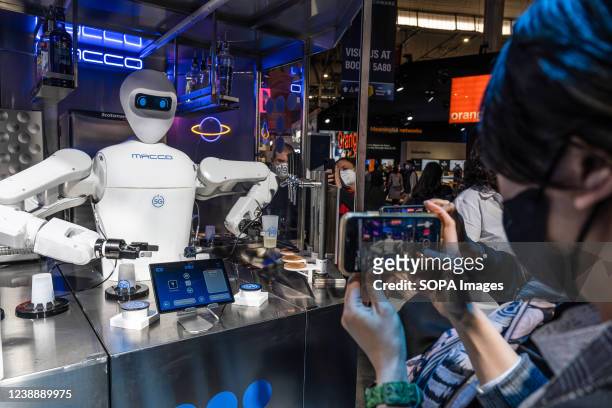 Visitor takes a photo of a Barman 5G waiter robot mixing drinks during the Mobile World Congress 2022. The third day of the Mobile World Congress...