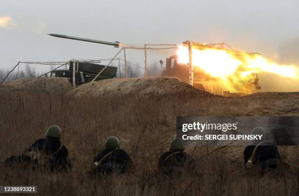 Soldiers look at the fire of Soviet "Grad" missile system during a drill at Divichki training ground about 90 km from Kiev 02 March, 2007. AFP PHOTO/...