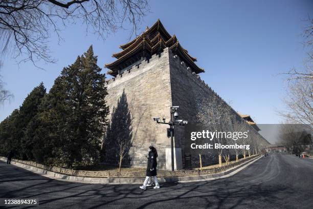 Pedestrian passes surveillance cameras near the Forbidden City in Beijing, China, on Thursday, March 3, 2022. China's consumer and retail shares...