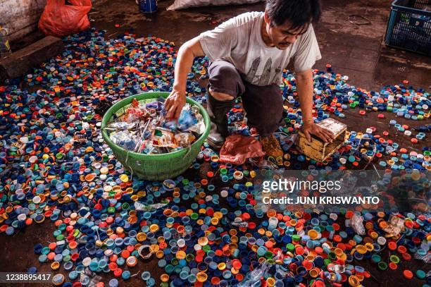 Worker sorts bottle caps collected in exchange for city bus tickets in Surabaya on March 3 before being resold to plastic recycling factories.