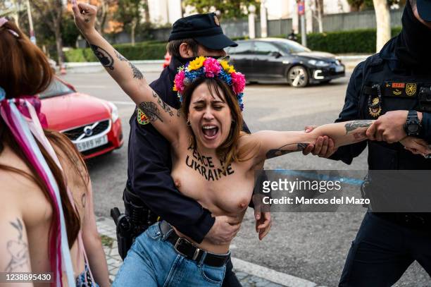 Officers of the Police Intervention Unit grabbing an activist of feminist group FEMEN removing her from the street while she protests bare-chested in...