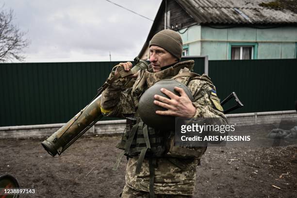 An Ukrainian soldier holds an anti-tank launcher at a frontline, northeast of Kyiv on March 3, 2022. - A Ukrainian negotiator headed for ceasefire...