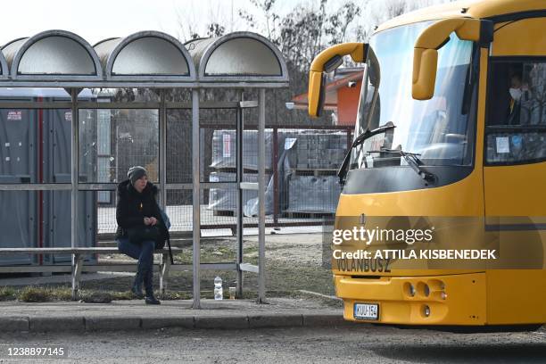 An Ukrainian refugee woman sits in the bus station at Tiszabecs village close to the Hungarian Ukrainian border on March 3, 2022.